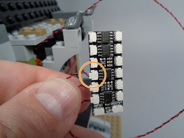 As shown by the orange circle in the second photo for this step, connect the second front porch light wire to plug #3 on the BRANCH12X adapter board.