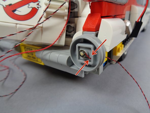 As shown by the orange circle in the first photo, pass the wire from another red Pico LED light through the square center of the round tail light frame.