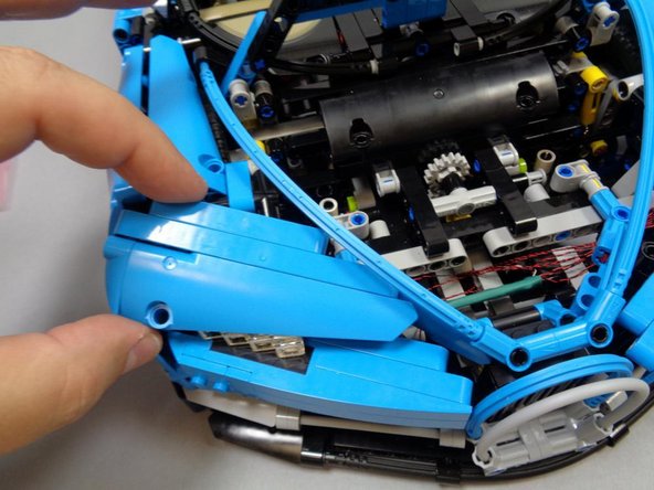 As shown in the second photo, re-attach the left and right blue Technic panels (headlight covers) that you removed in Step 3.