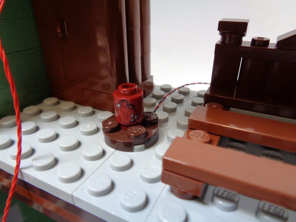 As shown in the first photo, re-attach the round red LEGO® brick with heart pattern so it covers the red Pico LED light. Make sure the heart pattern faces forward as shown in the photo.