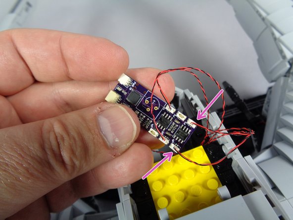 As shown by the two purple arrows in the photo for this step, connect the two engine light wires to plugs #3 and #4 on the effect controller.