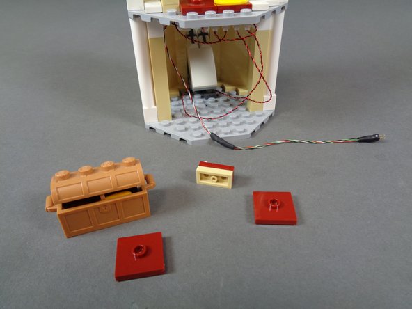 As shown in the first photo, remove the dark red parts and treasure chest from the floor of the lower tower room.