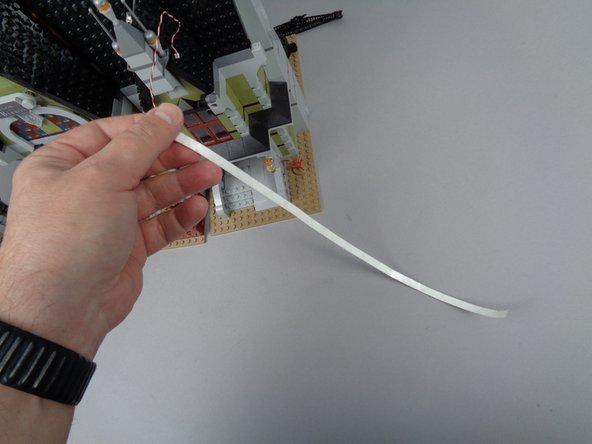 Be careful to remove only the backing, not the adhesive tape itself, as you need the back of the strips to be sticky so you can attach them to the inside of the elevator shaft.