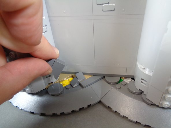 As shown in the third photo, re-attach the rock pieces you removed earlier.  These will hold the castle wall in its proper place one again.