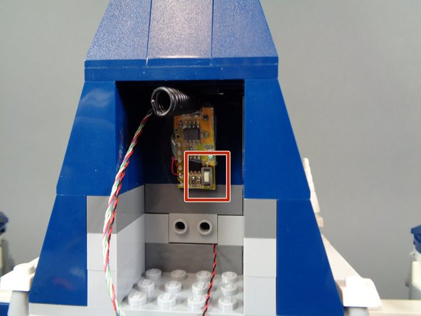 As shown in the second photo, take a large sticky square and attach it to the back of the remote receiver.