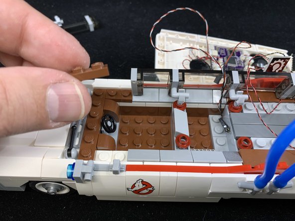 As shown in the three photos for this step, remove parts to make room for installing the searchlight.