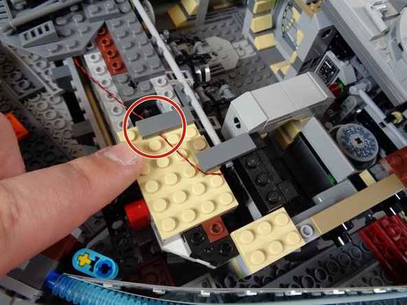 As shown by the blue circle in the first photo, you can wrap loose wire around Technic parts inside the Falcon frame.