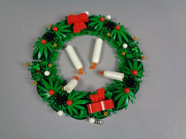 When the time comes to put your wreath into storage, you can keep the lights connected.  Just gently fold the four candles toward the inside of the wreath as shown in the photo, then carefully place inside the LEGO box.
