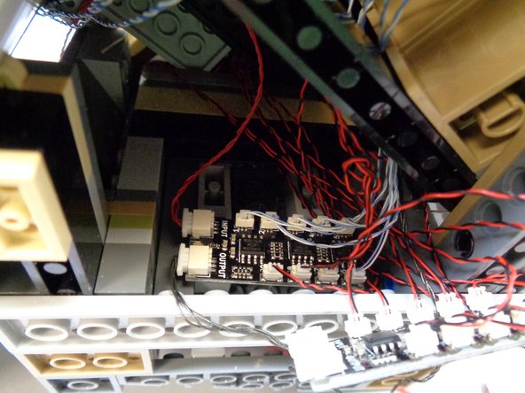 Using two sticky squares from Bag 1, carefully mount the first BRANCH09X adapter board inside the base of the castle as shown in the second photo.