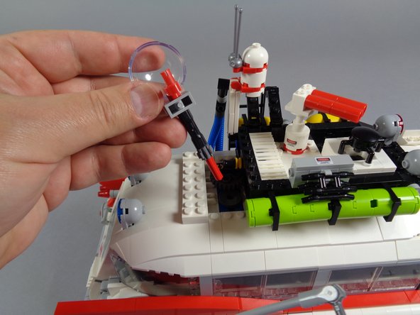 As shown in the first photo, carefully remove the roof radar dish, making sure to also remove the black Technic connector and red Technic axle connected to the radar dish.