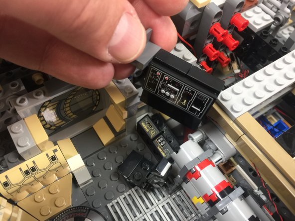 As shown in the third photo, remove the 1x4 black brick from the bottom of the computer panel assembly.