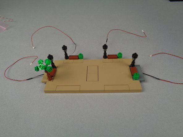 Use the same steps you've used before to mount Microflex LED lights into the four lamp posts on Panel 4F (shown by the four blue circles in the illustration for this step).