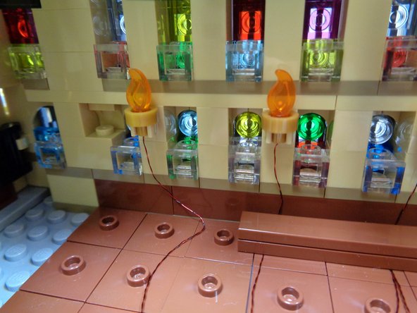 As shown in the first photo, run the wire from the fourth torch down the wall as you did for the first three torches.