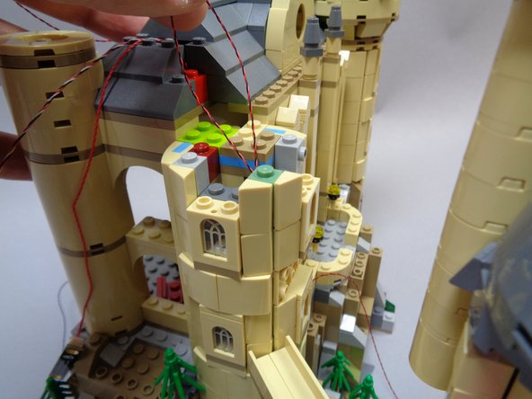 As shown in the photos for this step, re-attach the tan pieces around the three windows.