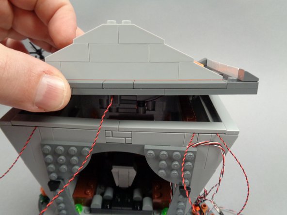 As shown in the first photo for this step, re-attach the town hall roof.