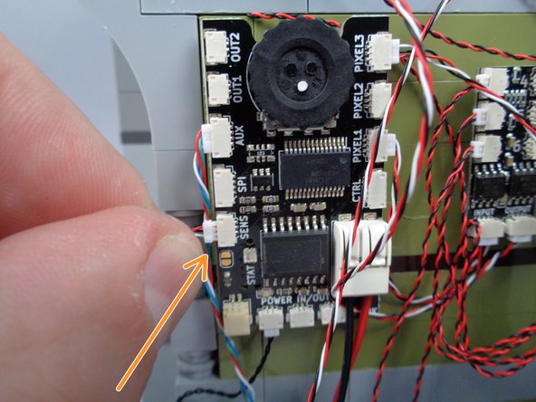 As shown by the orange arrow and circle in the photos for this step, connect the magnetic switch wire to the plug labeled &quot;SENS&quot; on the main effect controller.