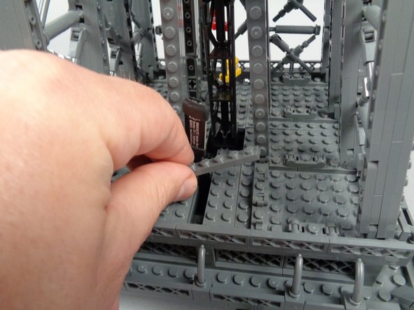 As shown in the photos for this step, replace the 1x8 plate you removed earlier, placing it sideways to hold the wire for the inter-level connecting board.