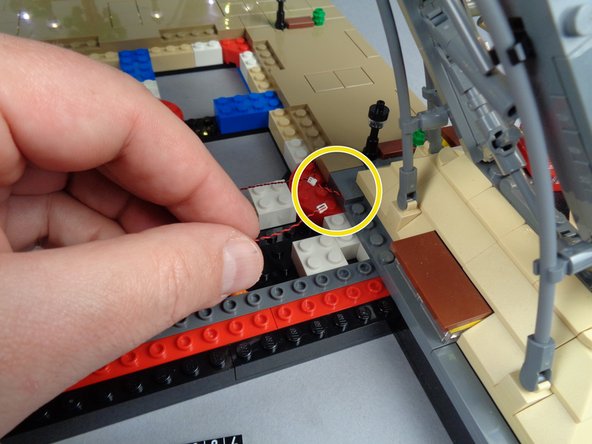 As shown by the yellow circle in the third photo for this step, make sure the light wires pass over the top of the round red brick, and that the wires pass between, not on top of, any studs.