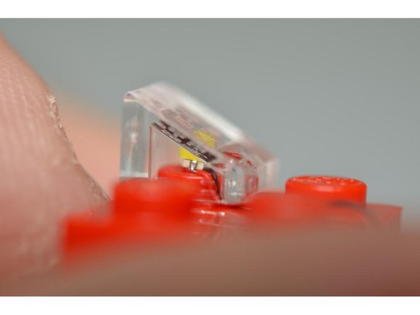 As shown in the photos, make sure the yellow part of the LED is facing up and is as close to the center of the LEGO® stud as possible when snapping the slopes on top of the LEDs.