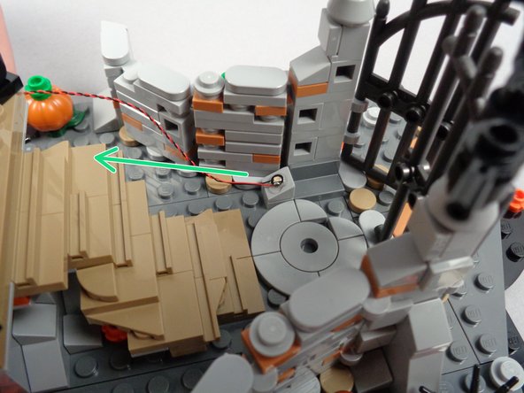 As shown by the green arrow in the second photo for this step, position the slope so the LED light shines up toward Jack's house.