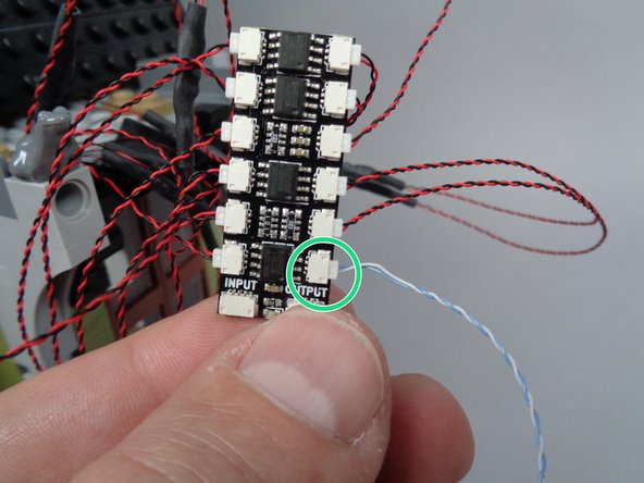 As shown by the green circle in the photo for this step, connect the first lightning LED light to plug #12 on the BRANCH12X adapter board.