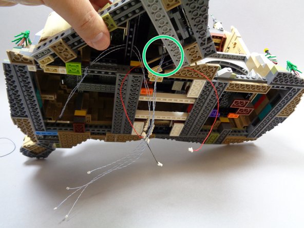 If you carefully lift the castle, you should see the four torch wires extending out the bottom as shown by the green circle in the third photo.