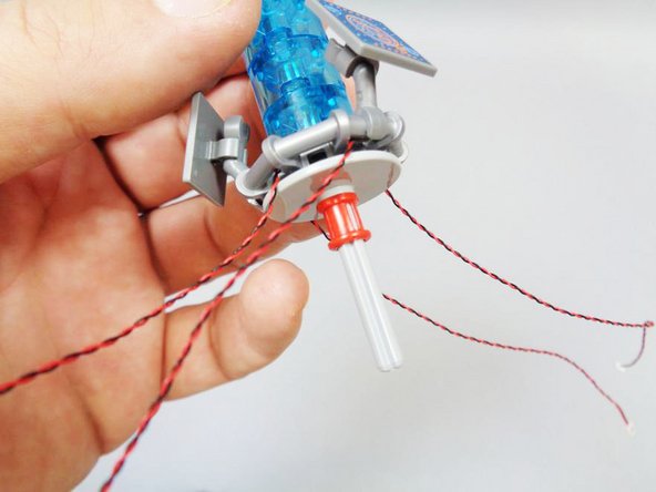 Note the red line in the photo-- the axle should extend above the disc, but not too far.  Just enough to catch the bottom of the console, but not too far that the axle pokes all the way through the bottom light blue round brick.