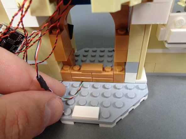 As shown in the second and third photos, begin re-assembling the stove, making sure all wires underneath bricks are running between, not on top of studs.