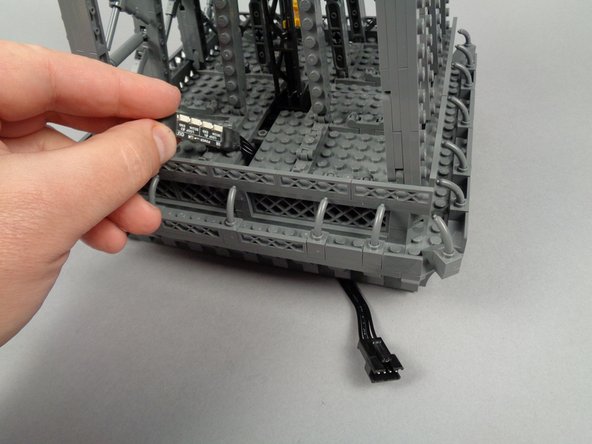 Your setup should now look like the third photo, with the plug for the inter-level connecting board passing down through the bottom of the top tower section.