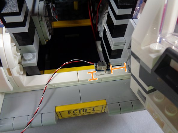 As shown in the first photo, stick one of the cut glue discs to the bottom of one of the switches.