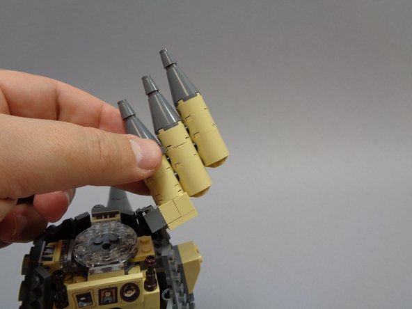 As shown in the second and third photos, remove the top of the tower and the section with the three smaller towers attached.