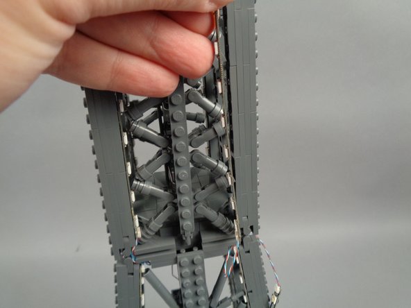 As shown in the photos for this step, attach the top of strip #1 to the tower frame, and re-position brace elements as needed to make room for the LED lights and strip.