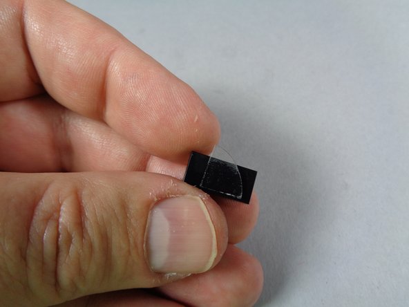 As shown in the first photo for this step, attach another cut glue disc to one of the three 1x3 black LEGO tiles included with your kit.