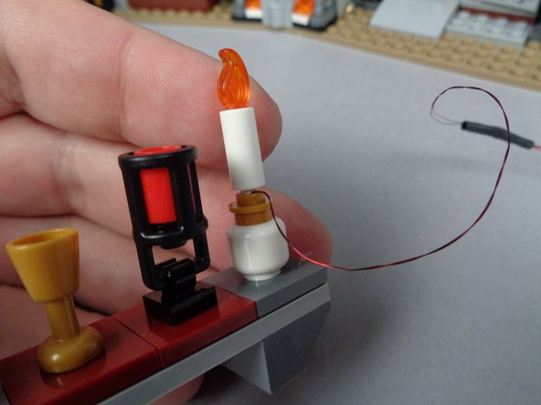 As you did with the four chandelier candles, leave a small amount of extra wire under the bottom of the candle.  This ensures the light wires don't become pinched when you insert the candles into the round gold LEGO plates.