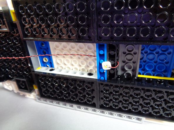 As shown in the second photo for this step, pull the LED light wire all the way through the hole.  This will provide some strain relief for the LED light and keep it in place.