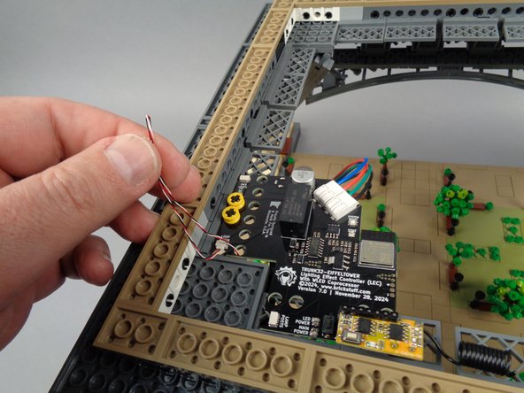 As shown in the second and third photos, you can gently pull any excess wire from the first control cable up through the hole in the main controller, then coil it up to hide any excess wire.