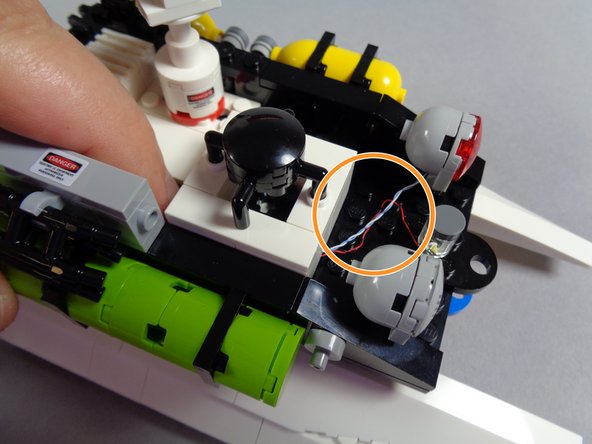 Before re-attaching the assembly, make sure all LED light wires are running between, not on top of, studs below the assembly, as shown in the first photo.