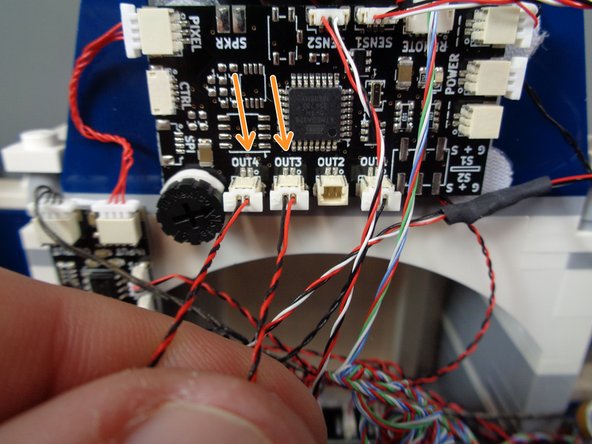 As shown by the orange arrows, connect the two torches to outputs OUT3 and OUT4 on the TRUNK08 master controller.