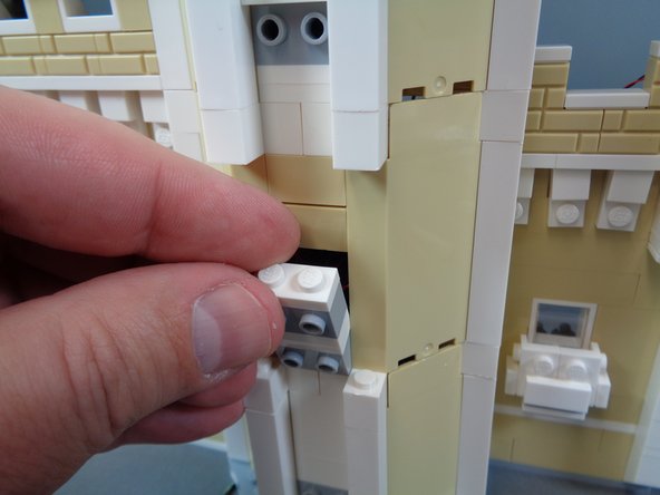 Continue carefully re-assembling the castle front as shown in the photos for this step, making sure not to pinch or pull any wires.