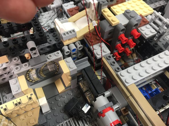 As shown in the third photo, re-attach the computer, making sure the two LED lights remain inside the transparent bricks.