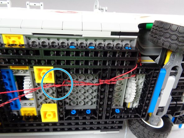 As shown in the first photo for this step, continue pulling the three wires toward the back of the car frame.