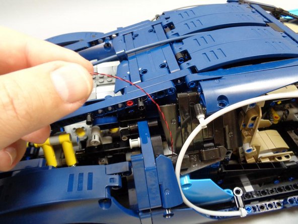 As shown in the second photo, gently pull the wire that you routed in the last step up toward the top of the vehicle.