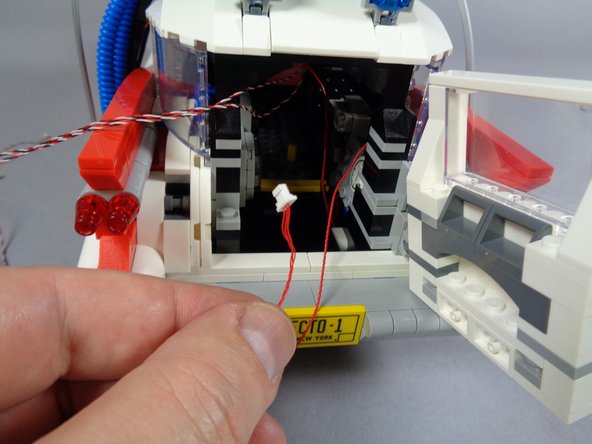 Next, take the red roof control wire, and pass its plug down through the same opening as the other wires.