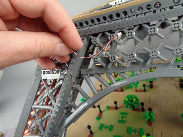 As shown by the first photo for this step, pull the control cable out the top of the pillar.