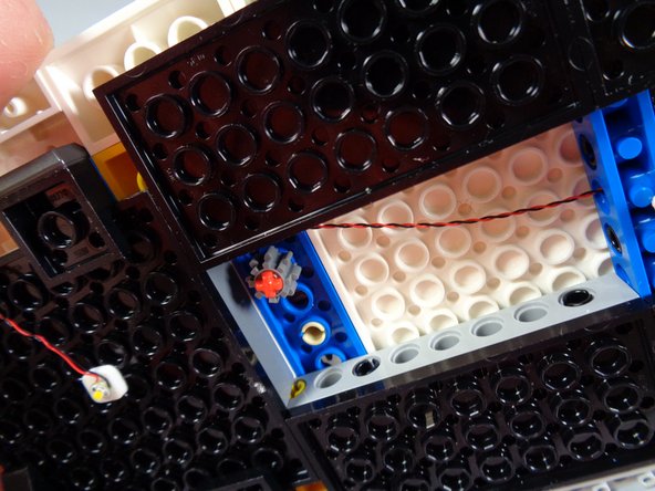 The second photo for this step shows the bottom side of the re-inserted axle.