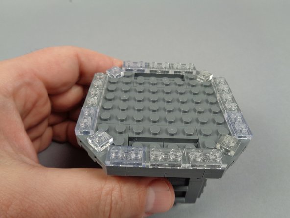 As shown in the photos for this step, continue disassembly by removing the four triangle/corner plates.