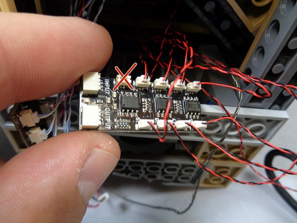 As shown in the first photo, gather the eight wires from the window lights that you fed down from the tower in the previous step.