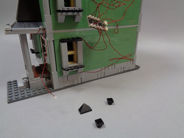 As shown in the first and second photos, remove the black window top pieces form the kitchen window, and run the side porch light wire above the kitchen window.