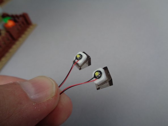 As shown in the second photo for this step, take those lights and stick them to the two LEGO slope pieces.