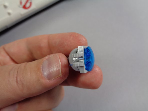 As shown in the photos for this step, finish re-assembling the hood spot light, taking care to make sure the light wire passes between the clip prongs and that the wire is not pinched when the light is re-attached to its bracket.